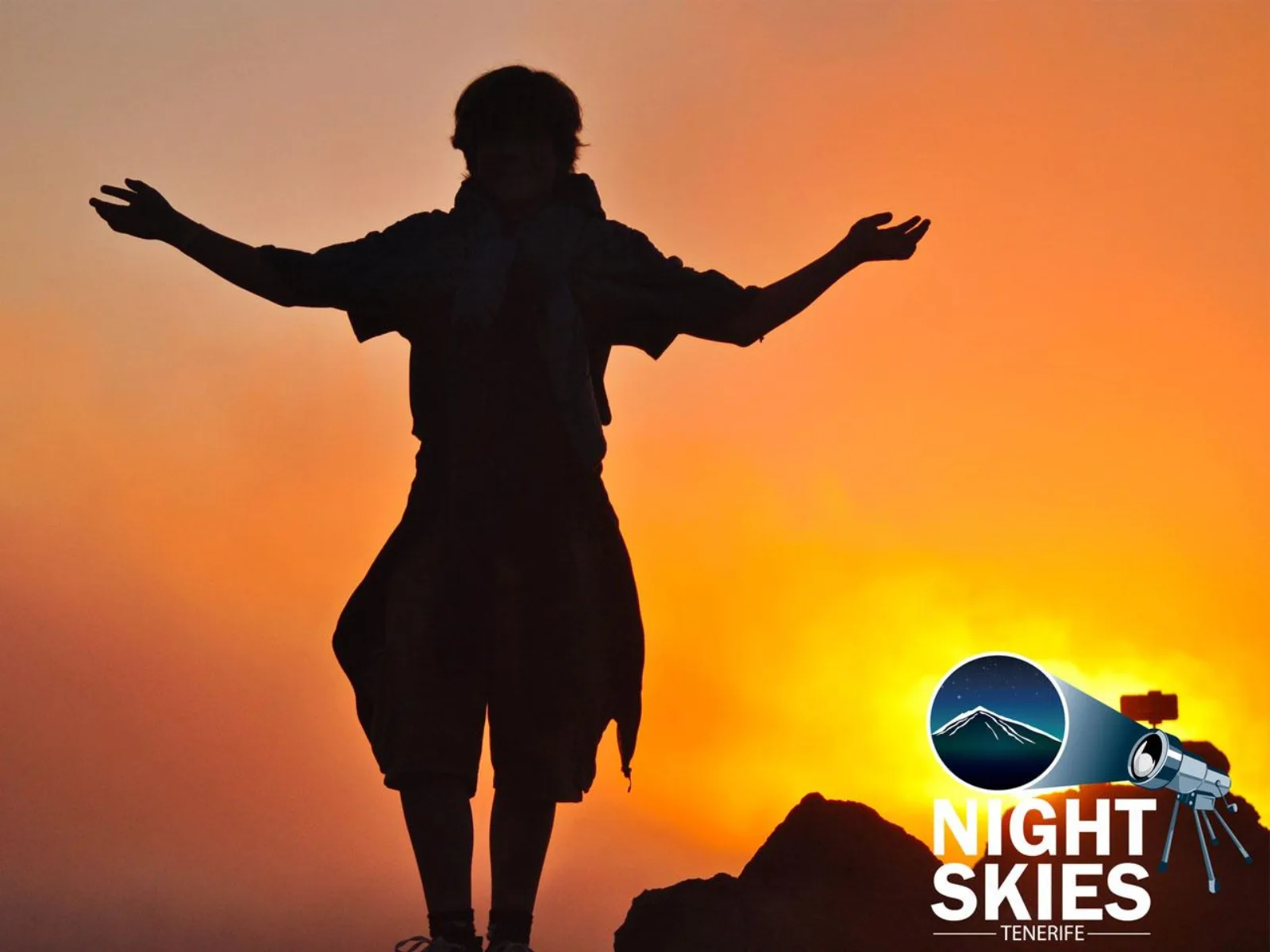 A figure silhouetted with arms outstretched against an orange sunset above the clouds