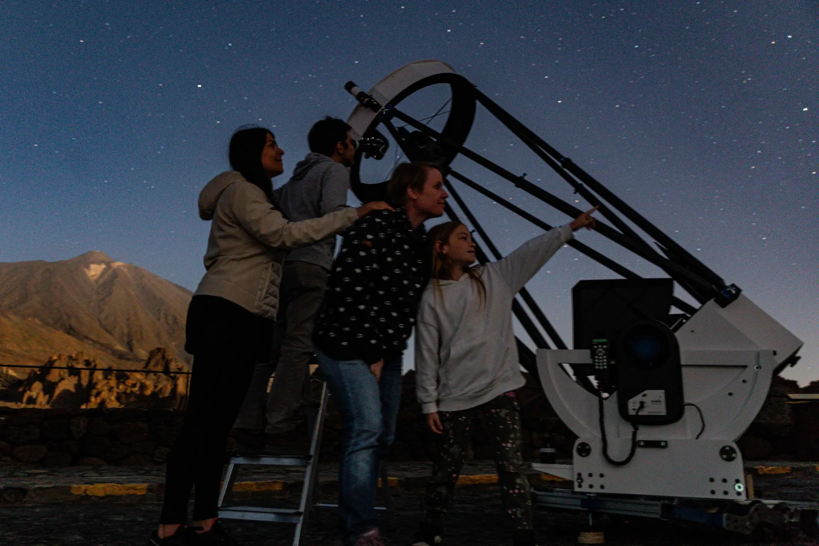Guests on a step-ladder at the eyepiece of the 32-inch Dobsonian, Teide behind them