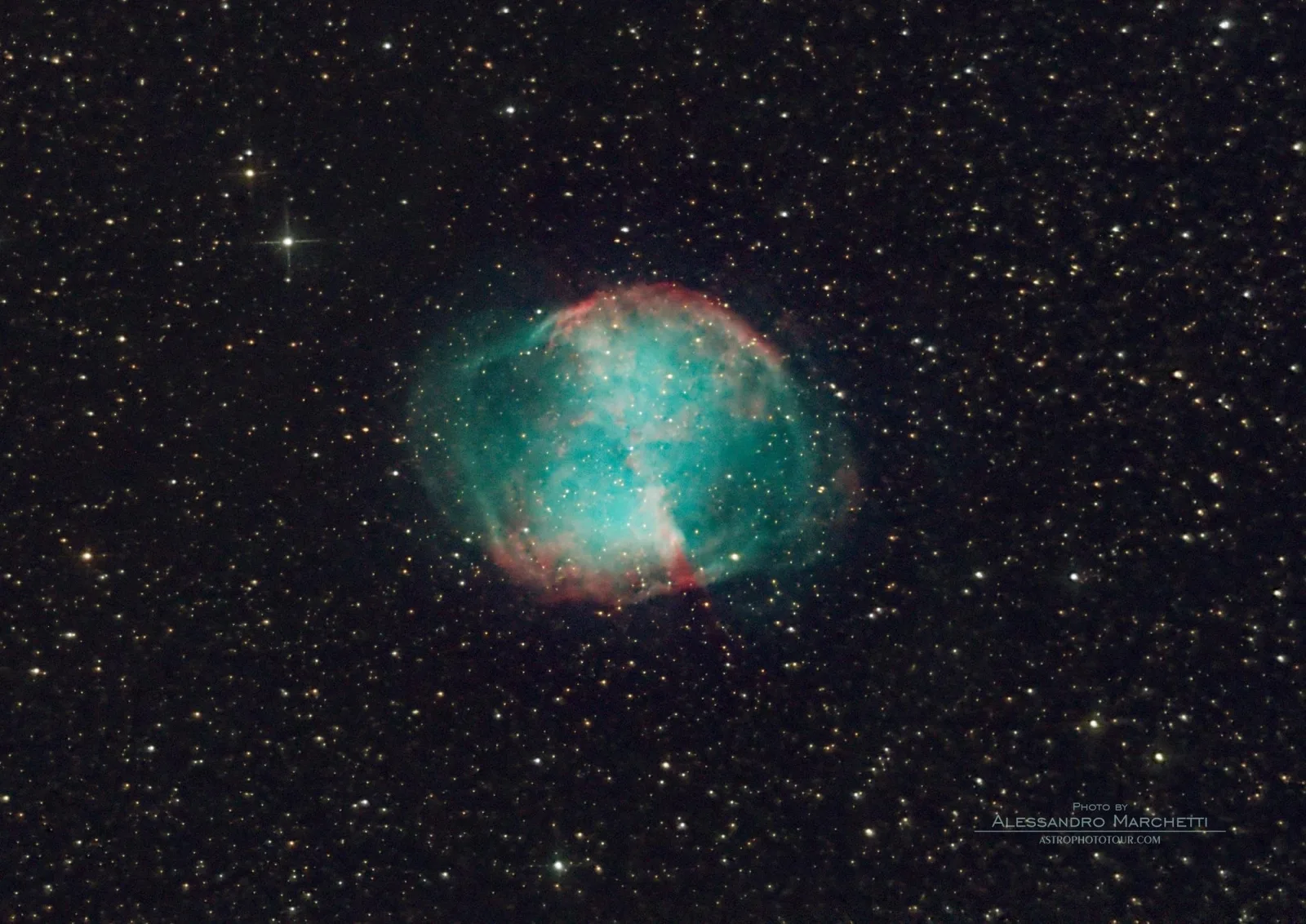The teal and red Dumbbell Nebula imaged through the telescope