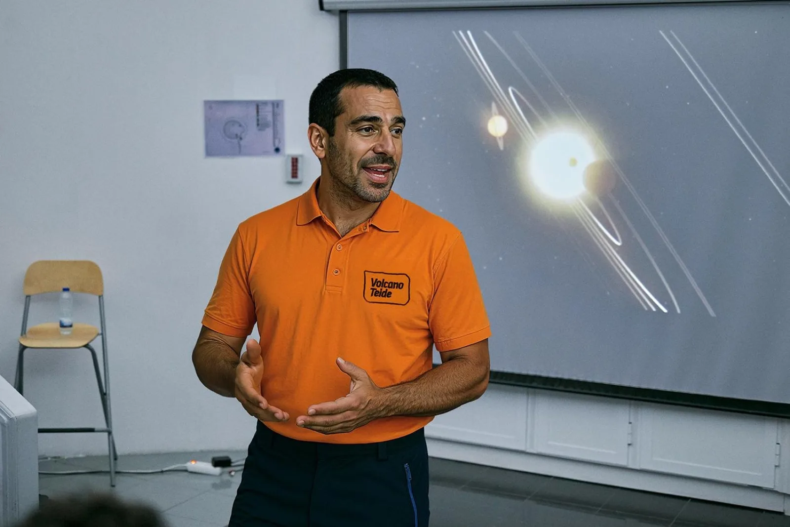 The guide presenting beside a projected image of the Sun