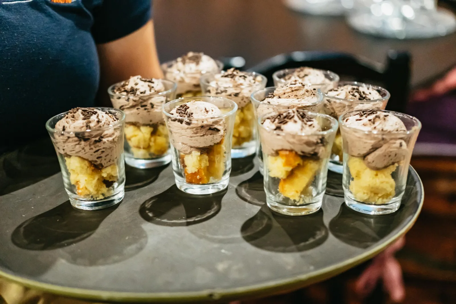A tray of individual dessert glasses carried through the restaurant